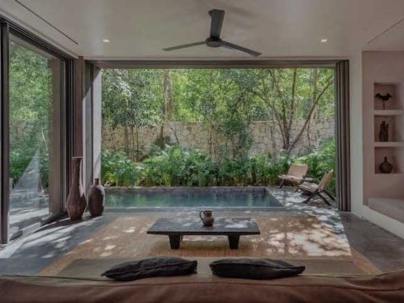Co-Lab Design residence interior at La Reserva Tulum with natural stone floors and hardwood carpentry.