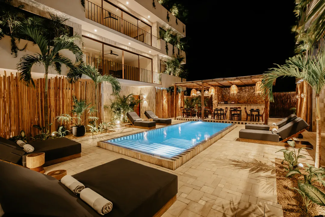 majaro-la-veleta-tulum-boutique-hotel-pool.webp Marble-striped infinity common pool between the two buildings at Majaró boutique hotel in La Veleta Tulum